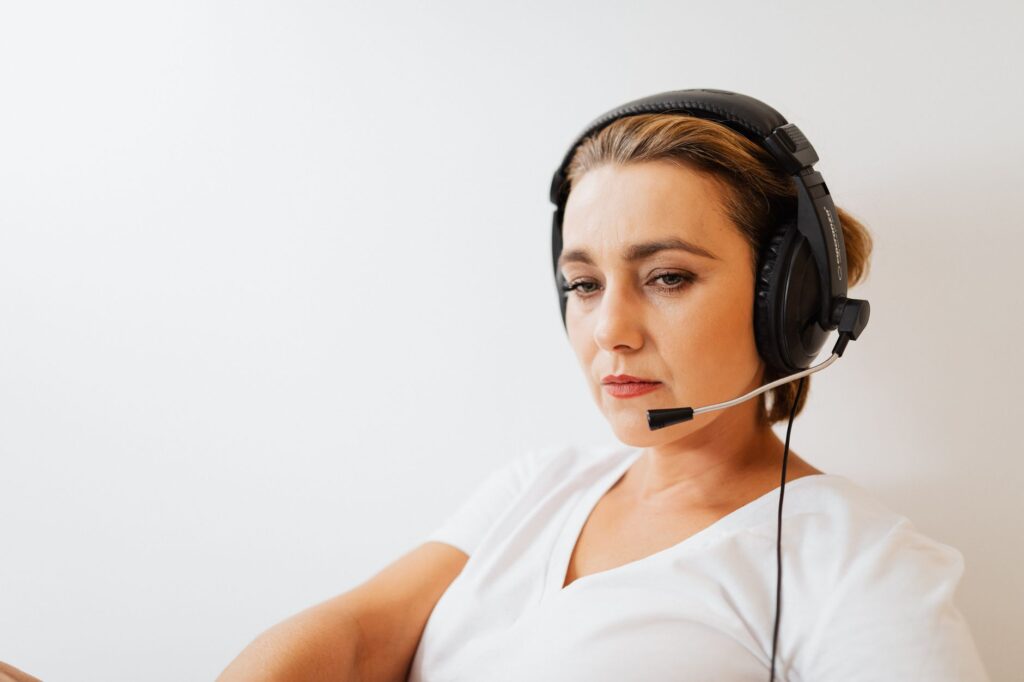 Operatrice di call center con cuffie alla postazione di lavoro